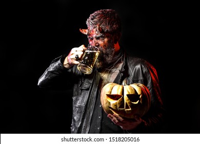 Happy Halloween - handsome Demon with glass beer isolated on dark background. Horror. Halloween Devil with bloody professional makeup