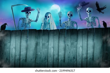Happy Halloween holiday background. Group of Funny skeletons peeking over a wooden fence.  Halloween card with copy space. - Shutterstock ID 2199496317