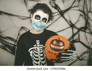 Happy Halloween. Kid Wearing Medical Mask In A Skeleton Costume With Halloween 
Balloon Over Gray Background