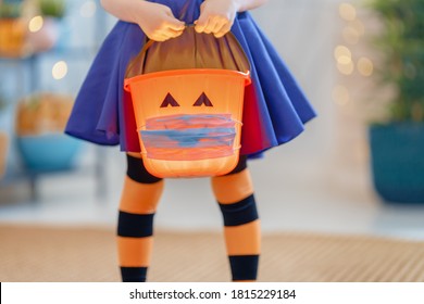Happy Halloween! Little Kid With A Basket For Sweets  Wearing Face Mask Protecting From COVID-19.