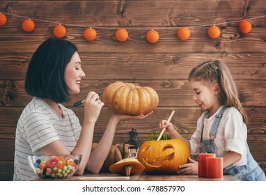 Happy halloween A mother and her daughter carving pumpkin. Happy family preparing for Halloween.
