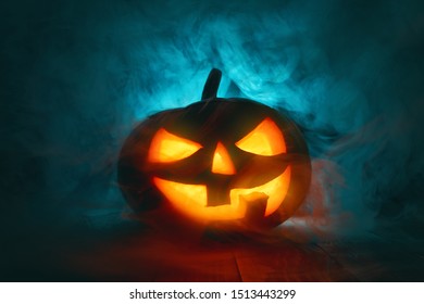 Happy Halloween! Pumpkin on wooden table on dark background.