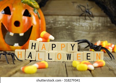Happy Halloween wooden blocks with candy corn and decor against an old wood background