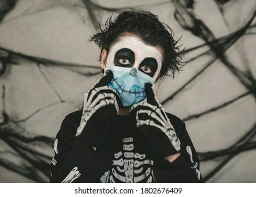 Happy Halloween,kid Wearing Medical Mask In A Skeleton Costume Making Smile Over Gray Background
