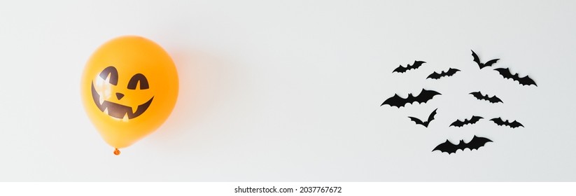 Happy Haloween concept. Wide Halloween banner with balloon ghost and bats on white background.