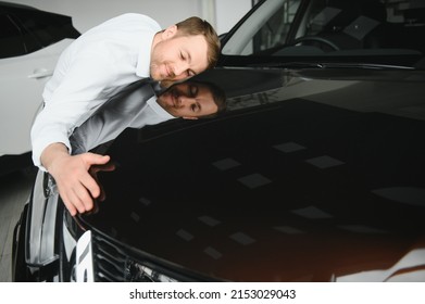 Happy Handsome Bearded Man Buying A Car In Dealership, Guy Hugging Hood Of New Car.