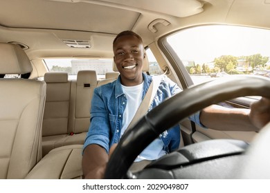 Happy Handsome Black Guy Driving His New Car, Going To Office Or Travelling, Copy Space. Smiling African American Young Man Sitting In Comfortable Auto, Having Car Trip Alone, Shot From Dashboard