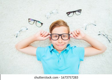 Happy Handsome Child Boy Trying On Glasses. Health, Medicine And Ophthalmology Concept