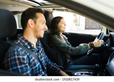 Happy Handsome Dad And Teen Daughter Laughing While Driving. Adolescent Girl Practicing Her Driving Skills With Her Father  