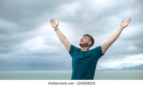 happy handsome free guy, young calm relaxed carefree man traveler with open raised hands enjoy sea, ocean view, person feeling good, breath deep deeply fresh air. Freedom, travel, happiness concept - Powered by Shutterstock