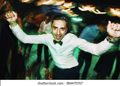 Happy handsome groom dancing & having fun at reception