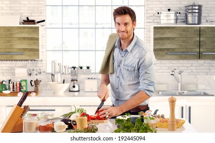 Happy Handsome Man Cooking In Kitchen At Home.