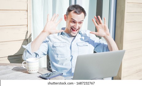 Happy Handsome Man Having A Facetime Video Call Talking To His Family. Smiling Casual Businessman Having A Video Conference Outside On A Sunny Day. Self Isolating At Home On Balcony Drinking Coffee. 