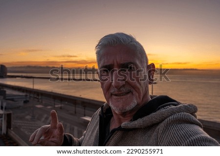 happy handsome middle aged man taking a selfie on the deck of a cruise ship - travel and vacation concept