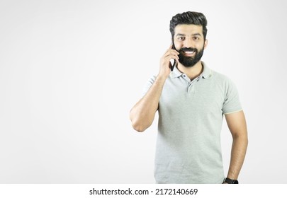 Happy And Handsome Young Bearded Man Standing And Holding A Cell Phone To The Ear - Pakistani, Indian, South Asian, Middle Eastern