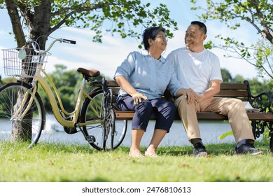 Happy and healthy couple Asian sitting chair beside a bicycle Family and friendship lifestyle, Enjoyment of active seniors, and outdoor activity after retirement, health care insurance concept - Powered by Shutterstock