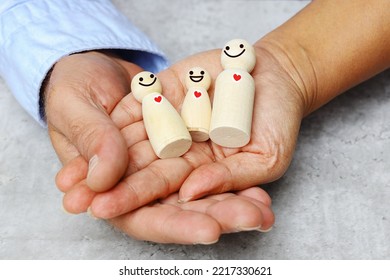 Happy healthy family concept, Man and woman's hand holding each other with wooden figures toys symbol of happy parent and baby smiling bonding together with love. - Powered by Shutterstock