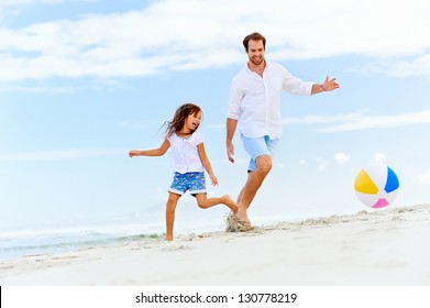 happy healthy family father and daughter running on the beach with ball having fun together - Powered by Shutterstock