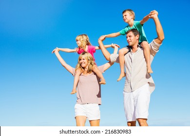 Happy Healthy Family Of Four Having Fun On Tropical Beach