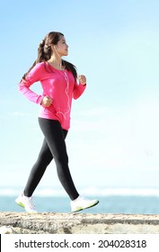 Happy healthy girl doing a brisk walking on the beach - Shutterstock ID 204028318