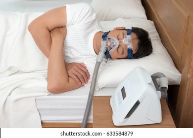 Happy And Healthy Senior Man Wearing Cpap Mask Sleeping Smoothly All Night Long On His Left Side Cross Arms Without Snoring.Obstructive Sleep Apnea Therapy, High Angle View.