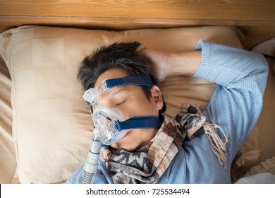 Happy And Healthy Senior Man Wearing Cpap Mask Sleeping Smoothly Without Snoring On His Back Open Arm.Obstructive Sleep Apnea Therapy,close Up  Top View.