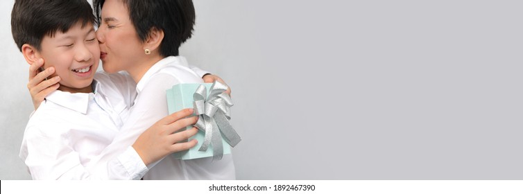 A Happy And Healthy Smart Looking Asian Preteen Boy Giving His Beautiful Mom A Gifts On Mother's Day Or Birthday. Love Expression, Parenting Teen, Single Mom, Preteen Son, Mother And Son, Banner.