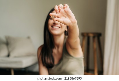 Feliz mujer saludable recomendando aceite de pez omega 3 y sosteniendo una píldora en su mano