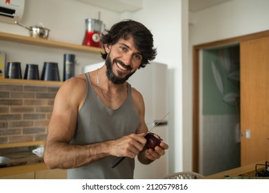 Happy And Healthy Young Man Meal Prepping Whole Vegetarian Meal In The Kitchen. High Quality Photo. Feel Good, Healthy And Health Concept.