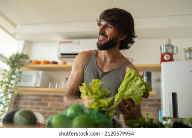 Happy And Healthy Young Man Meal Prepping Whole Vegetarian Meal In The Kitchen. High Quality Photo. Feel Good, Healthy And Health Concept.