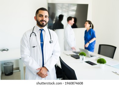 Happy To Help His Patients. Successful Hispanic Doctor And Hospital Director In A White Coat Getting Ready To Start A Meeting With The Medical Board