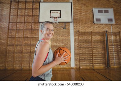 Happy High School Girl Standing With Basketball In The Court