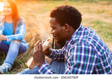 The Happy High School Student Is Sitting Outdoor And Eating A Kebab