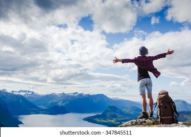 Happy hiker with her arms outstretched, freedom and happiness, achievement in mountains
