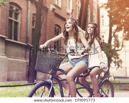 Happy hippie woman riding a tandem in the park 