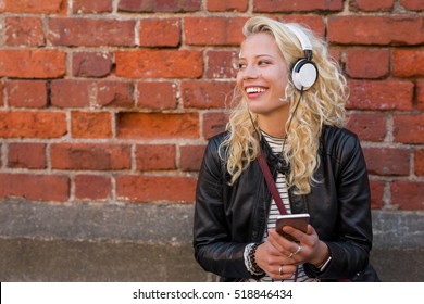 Happy hipster with headphones listening to music