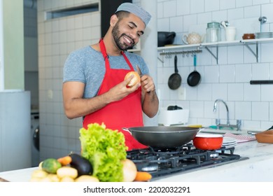 Happy Hispanic Cook With Red Apron Preparing Food At Kitchen Of Restaurant