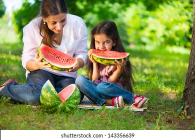 Happy Hispanic Family Eating Watermelon At Park