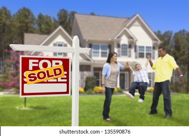 Happy Hispanic Family In Front Of Their New House And Sold Home For Sale Real Estate Sign.