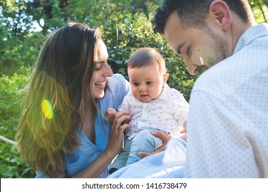 Happy Hispanic Family Having Fun Together Outdoors. Lovely Family Spending Time Together In The Park. Cute Spanish Couple Playing With Their Kids Outdoors. Family Concept.