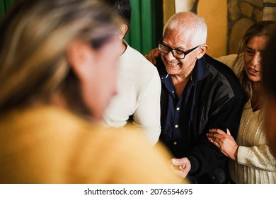 Happy Hispanic Family Having Fun During Winter Time At Home - Focus On Grandfather Face