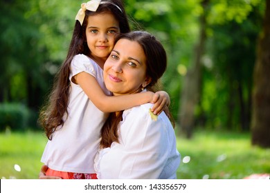 Happy Hispanic Family Playing In Sunny Park