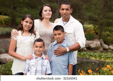 Happy Hispanic Family Portrait In The Park.