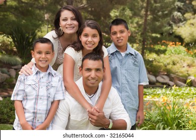 Happy Hispanic Family Portrait In The Park.