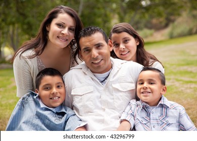 Happy Hispanic Family Portrait In The Park.