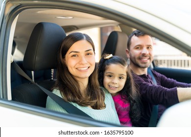 Happy Hispanic Family Sitting In Car During Weekend