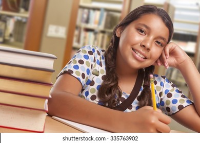Happy Hispanic Girl Student with Pencil and Books Studying in Library.