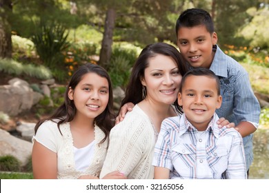 Happy Hispanic Mother And Children In The Park.