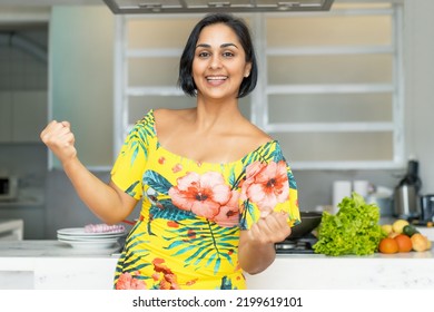 Happy Hispanic Mother Or Housewife At Kitchen Indoors At Home