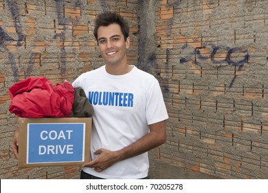 Happy Hispanic Volunteer With Coat Drive Donation Box